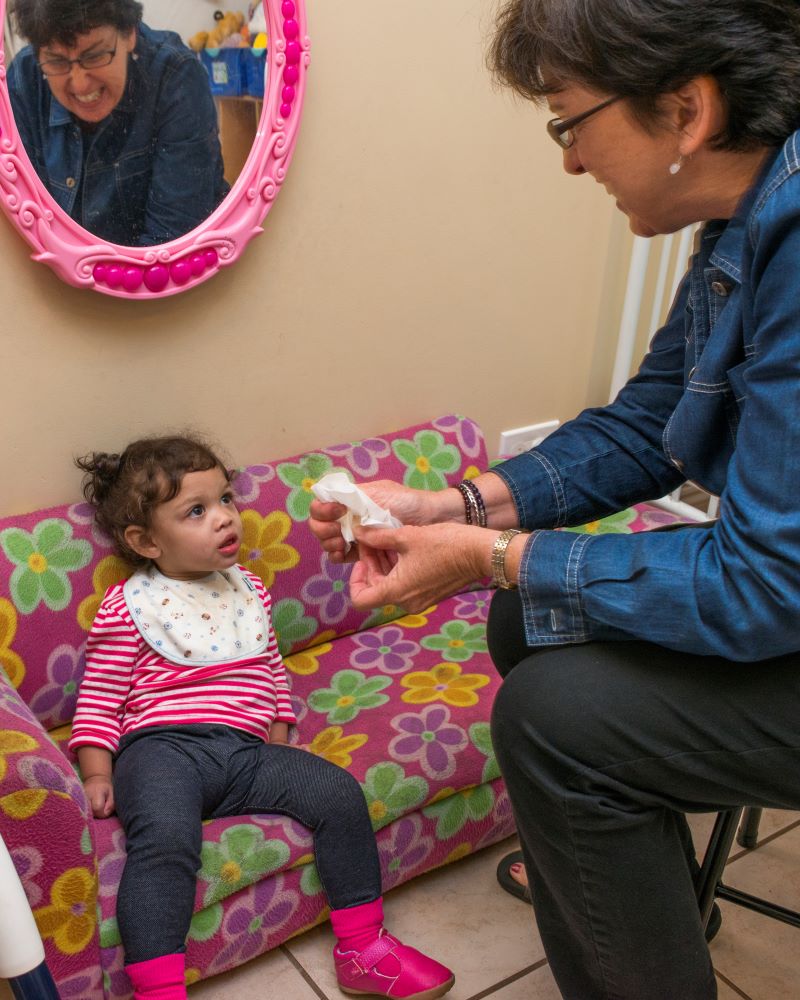 Sick little girl being attended to by a woman.
