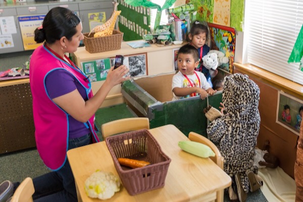 Niños y maestra jugando con verduras.