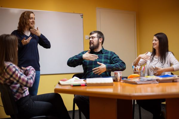 A un grupo de personas se les muestra cómo hacer un gesto con las manos.