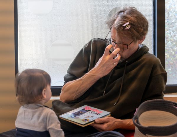 Teacher Sam signs “mad” to a baby