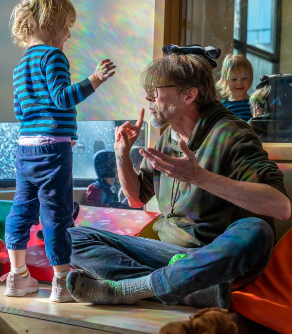 Teacher Sam signs “Where?” to a toddler