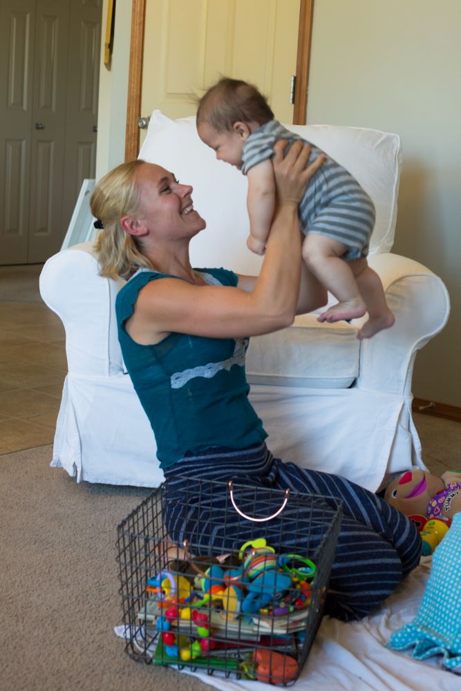 Smiling mother holding up her baby.